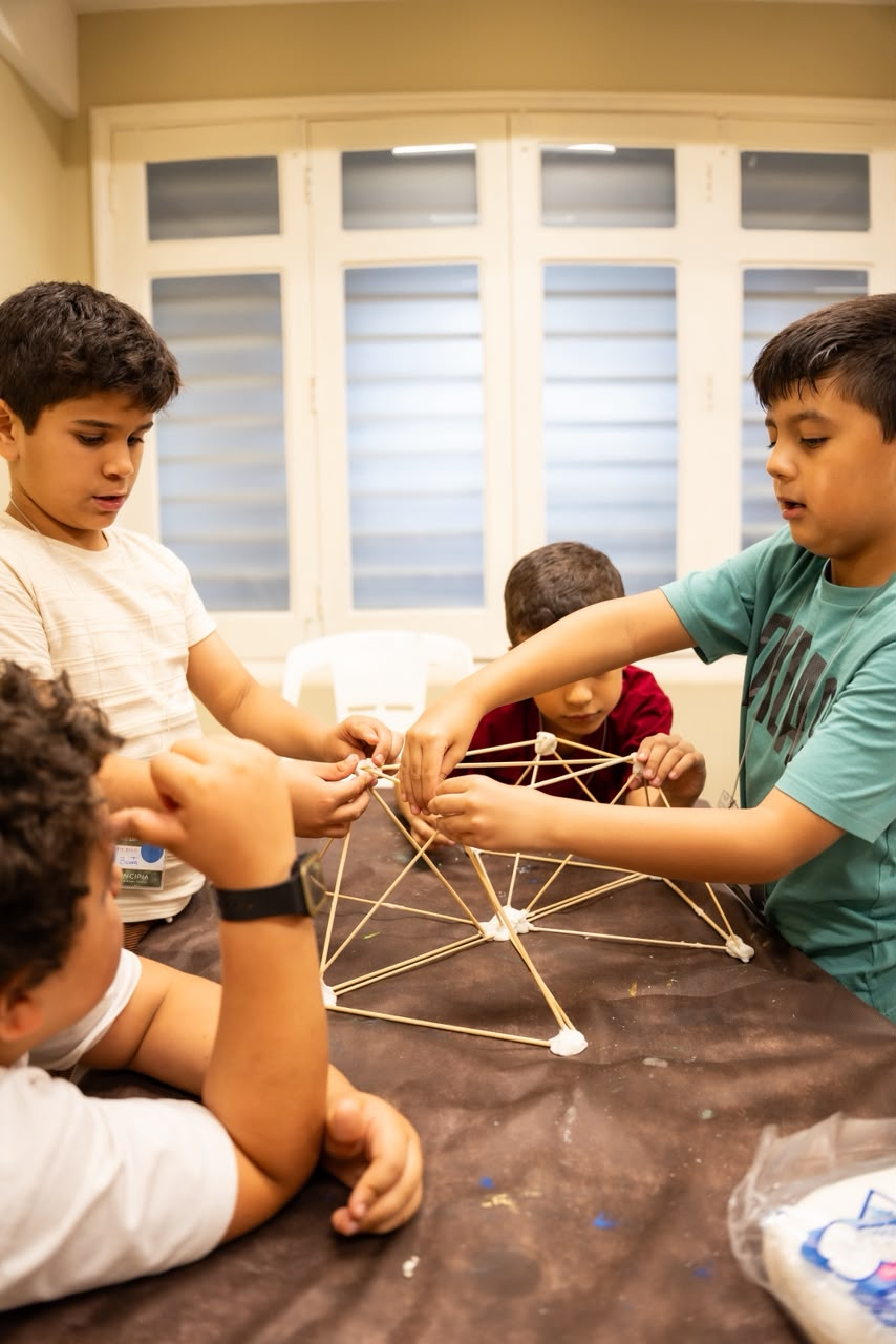 Meninos construindo uma estrutura com palitos.